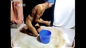 Naked slave cleans up after mud party while being penetrated
